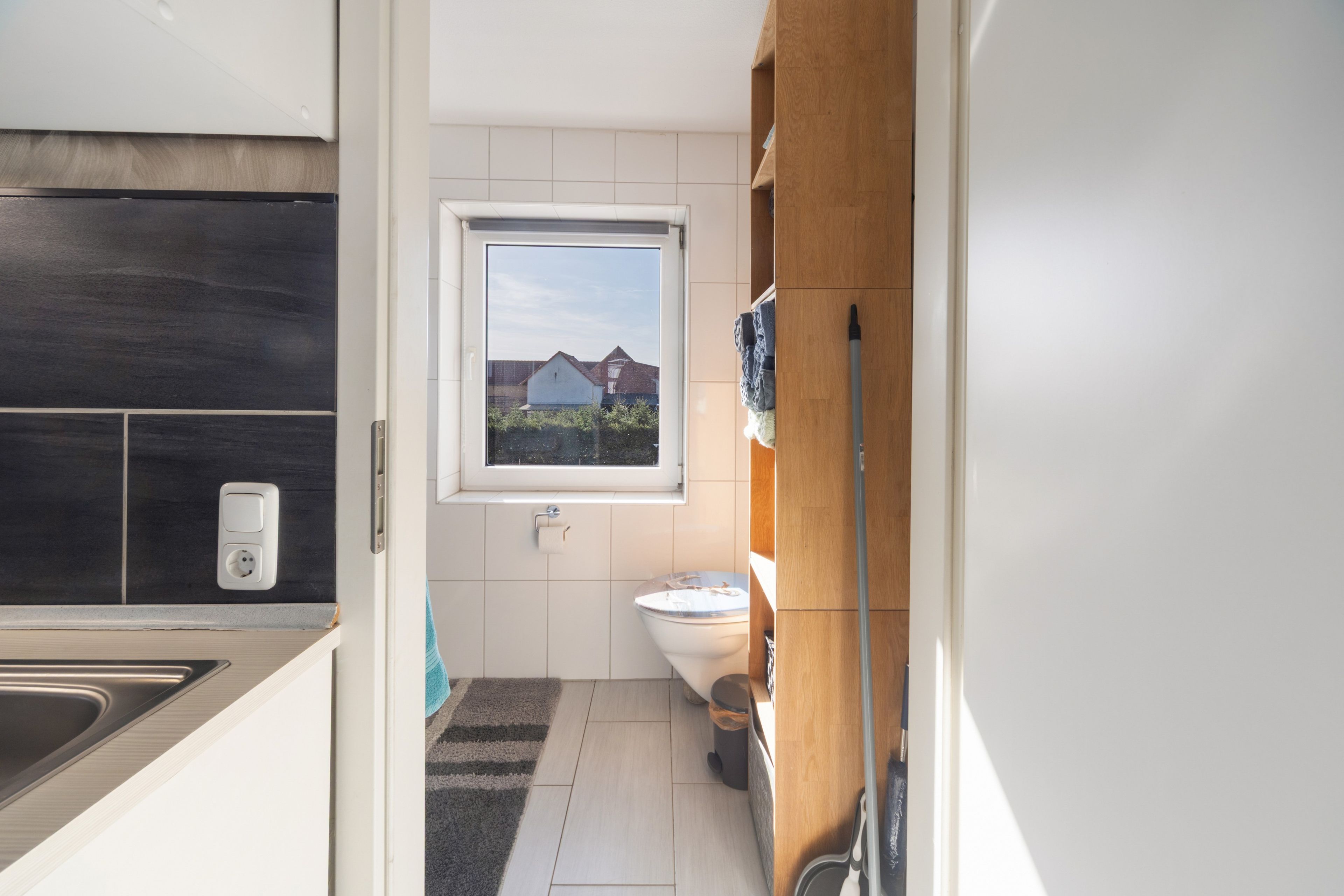 Ein modernes Badezimmer mit Toilette, Waschbecken und Fenster.