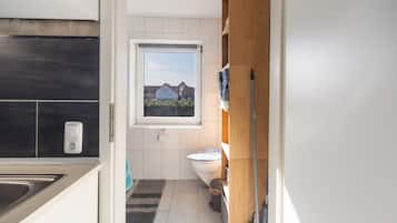 Ein modernes Badezimmer mit Toilette, Waschbecken und Fenster.