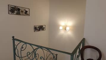 Eine Treppe mit Metallgeländer und einer Wandleuchte.