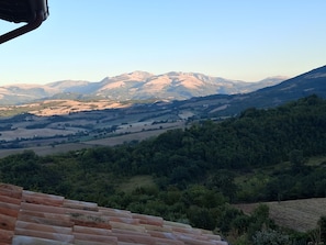 A mountainous landscape with terraced fields and a clear sky. - Buon Vento (Camerino)