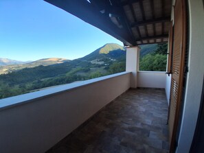 A balcony with a view of a mountain range.