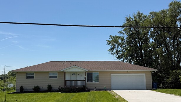 A single-story house with a garage, a front lawn, and a driveway. - Shoreline Haven (Erie)