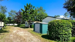 Um camping com várias casas móveis, um caminho de cascalho e arbustos verdes.