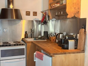 A kitchen with a stove, oven, and a wooden countertop. - Apartment for 4 people near the slopes (La Salle-les-Alpes)
