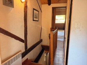 A narrow stairway with wooden handrails and a white wall with a single framed picture. - Apartment for 4 people near the slopes (La Salle-les-Alpes)