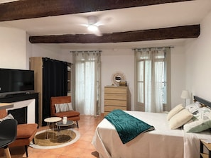 Una habitación con cama, televisión, escritorio y silla.