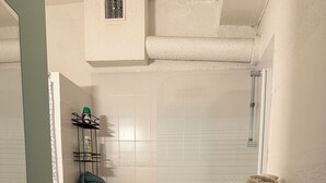 Un baño con bañera, lavadora y tendedero.