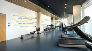 A gym with exercise equipment, a wall with motivational phrases, and a large window. - Student Only Palamon Court (Canterbury)
