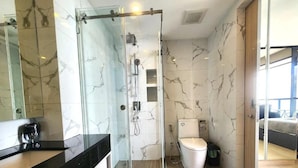 Une salle de bain moderne avec une douche à parois de verre, des toilettes et un lavabo.