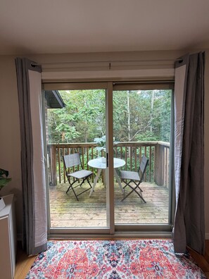 A room with a sliding glass door leading to an outdoor deck with a table and chairs. - Peaceful Parkside End Unit | 3 Bedrooms | Sleeps 8 (Barrie)
