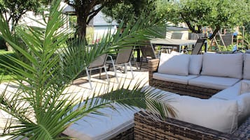 An outdoor seating area with wicker furniture and a sofa.
