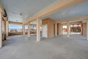A spacious interior with high ceilings and a balcony overlooking a construction site. - Beach Estate (Gulf Shores)