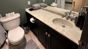 Un bagno con servizi igienici, lavandino, specchio e portasciuga.