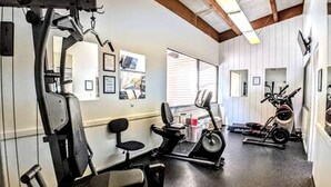 Una palestra con attrezzature per esercizi, tapis roulant e cyclette.