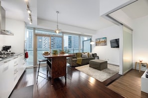 A modern apartment with a kitchen, dining area, and living space. It features large windows, a city view, and a minimalist design. - Stylish 1BR APT near DWTN with Balcony Views (Toronto)