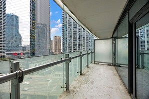 A balcony with a metal railing, a glass barrier, and a view of high-rise buildings. - Stylish 1BR APT near DWTN with Balcony Views (Toronto)