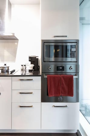 A modern kitchen with a built-in microwave, oven, and coffee maker. - Stylish 1BR APT near DWTN with Balcony Views (Toronto)