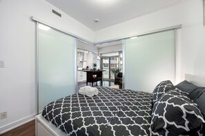 A bedroom with a bed, a desk, and a chair. - Stylish 1BR APT near DWTN with Balcony Views (Toronto)