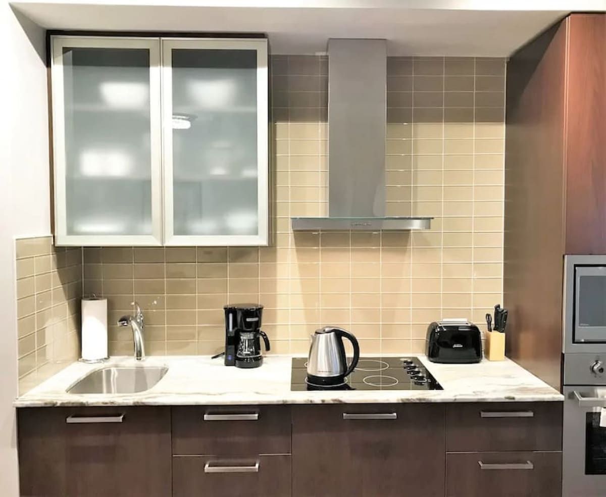 A modern kitchen with a sink, stove, and cabinets.