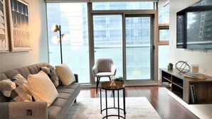 A modern living room with a sofa, a side table, and a chair. - Downtown Condo with Juliette Balcony and Parking (Toronto)