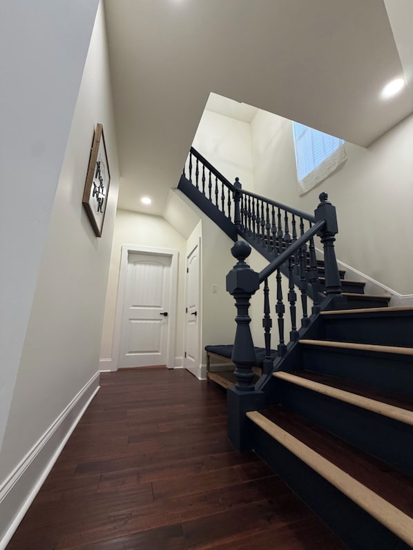 A staircase with a dark balustrade leading to a landing.