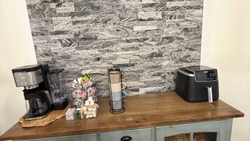 A kitchen counter with a coffee maker, a blender, and a mug holder.