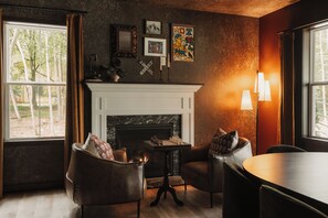 A cozy room with a fireplace, leather armchairs, a chessboard, and a dining table. - 2026 Build, Private Pool, Hot Tub+Sauna+Game Floor (Albrightsville)