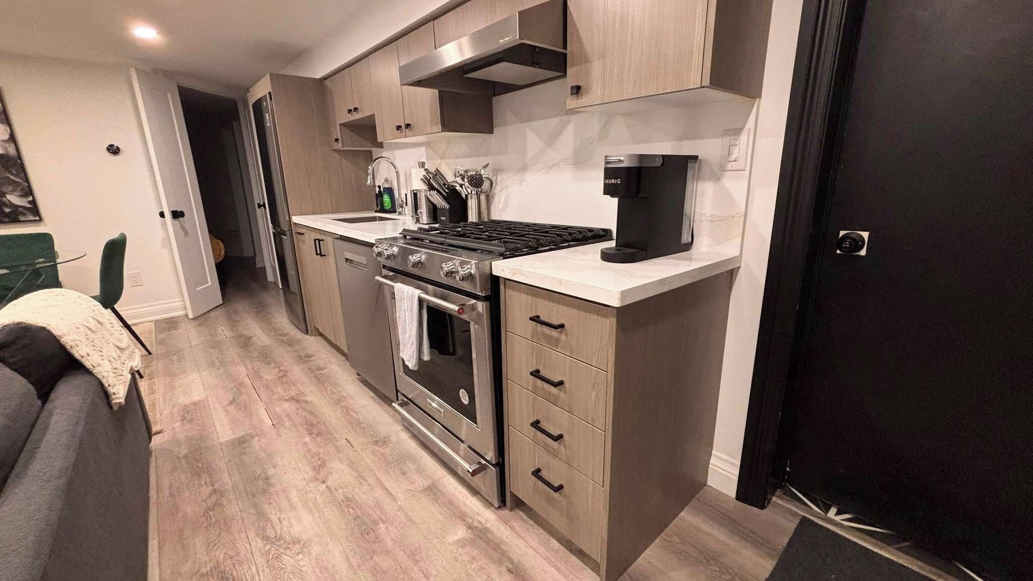 A compact kitchen with a stove, oven, and a coffee maker on the countertop.