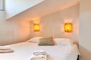 Ein Hotelzimmer mit einem Bett, zwei Wandlampen und einem Fenster.