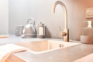 A modern kitchen with a stainless steel sink, a kettle, and a coffee maker. - Cosy Escape with A/C in Old Town (Bordeaux)