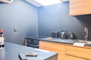 Eine moderne Küche mit integriertem Backofen, Wasserkocher, Toaster und Spüle.