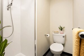 A bathroom with a toilet, a shower, and a towel rack. - Student Only Spring Gardens (Aberdeen)