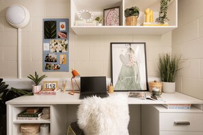 A well-organized workspace with a laptop, framed artwork, and a bulletin board with photos and notes. - Student Only Spring Gardens (Aberdeen)