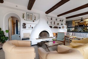 A living room with a fireplace, seating area, and a bookshelf.