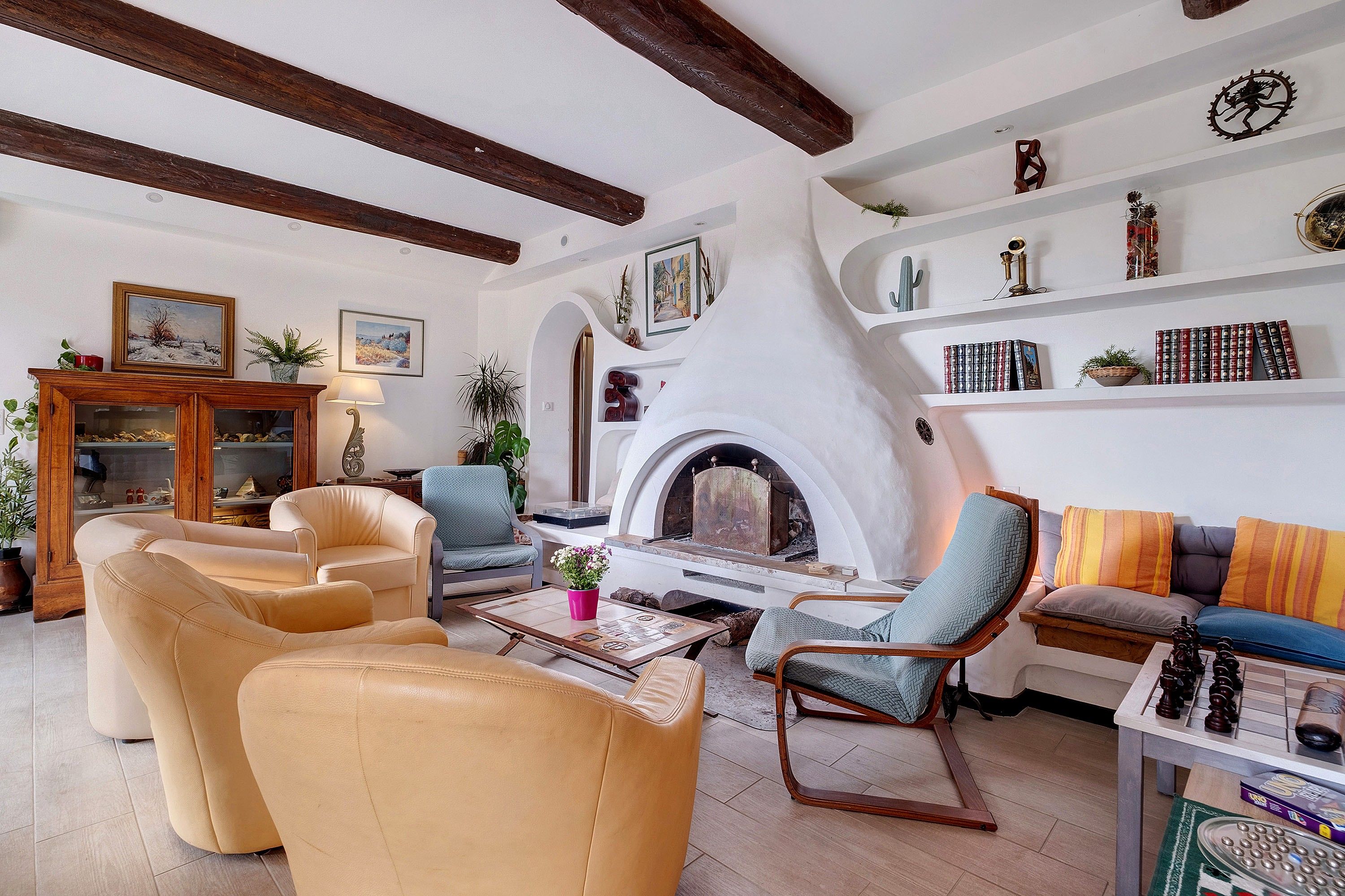 Una sala de estar acogedora con chimenea, sofás de cuero y una estantería.