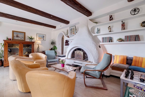 Una sala de estar acogedora con chimenea, sofás de cuero y una estantería.