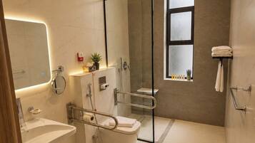 Un baño moderno con ducha de vidrio, lavamanos e inodoro.