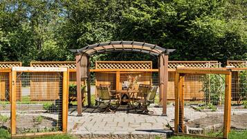 Puinen pergola, puutarhapatio, pöytä ja tuolit sekä aidattu alue, jossa näkyy numero 302.
