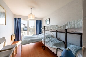 A bunk bed room with a desk, chair, and a window with curtains. - Seaside Apartment in Blankenberge With Sea Views (Blankenberge)