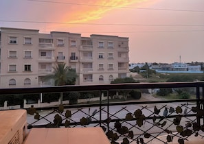 A multi-story residential building with balconies, a clear sky, and a view of the surrounding area. - Crossroads Hideaway (Sidi Daoud)