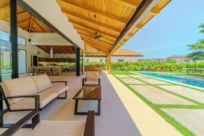 Un área de estar al aire libre con piscina y vistas del paisaje circundante.