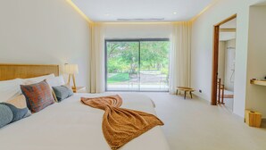 Een hotelkamer met een groot bed, uitzicht op de omgeving en een badkamer met douche.