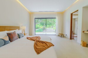 Habitación de hotel con una cama grande, vistas al exterior y un baño con ducha.