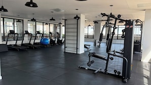 Une salle de sport équipée de tapis de course, de vélos elliptiques et de matériel de musculation.
