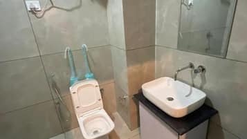 Ein Badezimmer mit Toilette, Waschbecken und Spiegel.