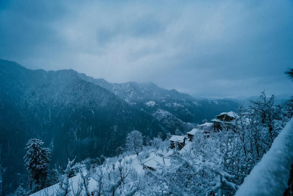 Un paisaje montañoso cubierto de nieve con edificios.