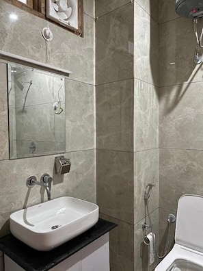 Une salle de bain avec un lavabo blanc, un miroir et une douche.