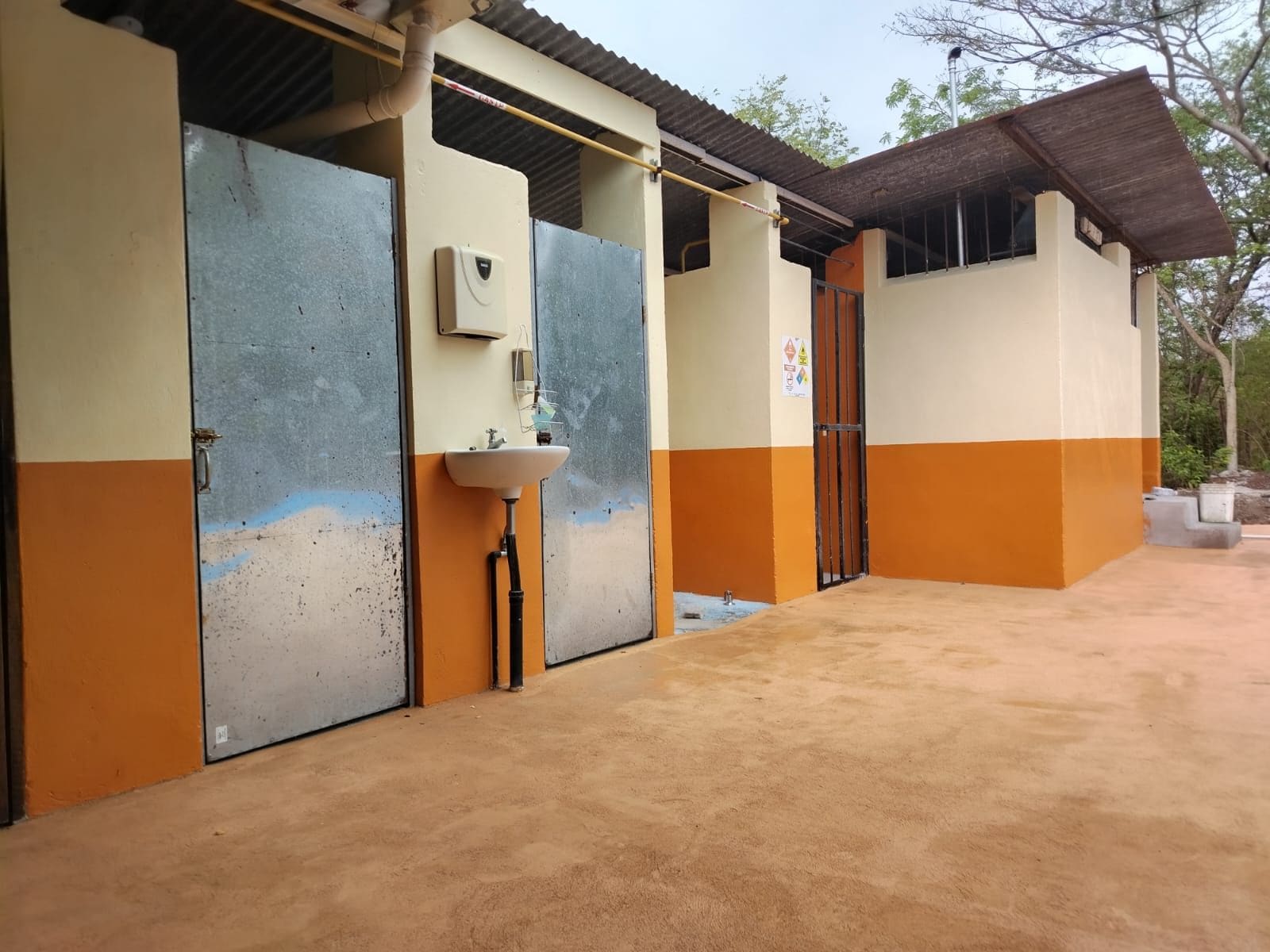 A building with a concrete floor, a sink, and a door.