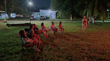 A group of people seated on lawn chairs in an outdoor setting at night.