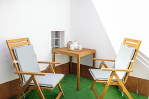 A corner room with two wooden chairs, a small table, and a white wall with a window. - An oasis of peace in the heart of Valle Gran Rey (Valle Gra Rey)